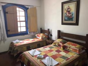 圣若昂-德雷Pousada Sinhá Moça的两张睡床彼此相邻,位于一个房间里