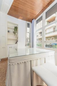 奥里韦拉Apartamento San Pascual en Orihuela的厨房配有白色的柜台和一些窗户。