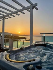 阿赫托波尔AGATA BEACH Boutique Adult Only的一座房子甲板上的热水浴缸,享有日落美景