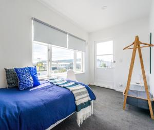 旺阿马塔旺阿马塔冲浪住宿旅舍的一间卧室设有蓝色的床和大窗户