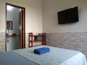 特林达德Pousada Marimbá的卧室配有一张壁挂式平面电视的床。