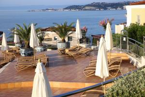 萨武德里亚Skiper Resort Savudrija - Umag - LGP的一个带椅子和白色遮阳伞的庭院和大海