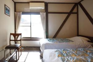 高山樱花宾馆的一间卧室设有两张床和窗户。