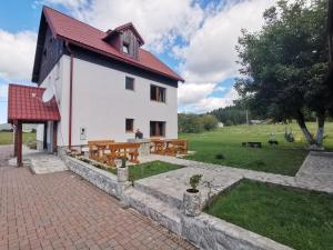 Gornji Babin PotokPlitvice Antico的白色的建筑,有红色的屋顶和长凳