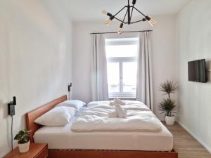 梅拉诺Rosa Rooms Meran的一间卧室配有一张带白色床单的床和一扇窗户。