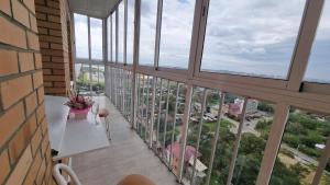 伊尔库茨克伊库斯基贝利加公寓式酒店的阳台设有窗户和鲜花桌。