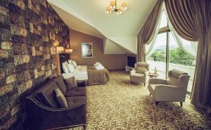 杰尔宾特Elgarden Hotel & Spa的酒店客房配有一张床、一张沙发和椅子。