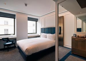 伦敦Page8, Page Hotels的一间卧室配有一张床、一张书桌和一面镜子