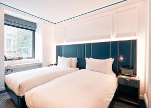 伦敦Page8, Page Hotels的一间卧室设有两张床和窗户。