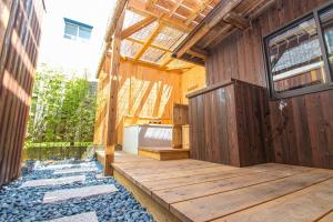 福冈Machiya Villa Seian - Vacation STAY 11749的木质房屋,铺有木地板,设有木制甲板