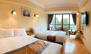 中正高峰大饭店的酒店客房设有两张床和电视。