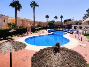 维拉Villa Laguna - your duplex in the sun!的一个带遮阳伞和桥梁的游泳池