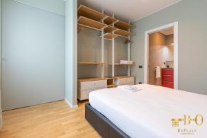 米兰BePlace Bocconi Apartments的一间卧室配有床和开放式架子