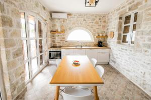 科帕罗Vila Leon - Old Qeparo的厨房配有木桌和白色椅子
