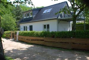 因塞尔波埃尔Ferienhaus Sonnenschein的前面有木栅栏的白色房子