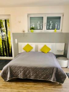 凯撒斯劳滕Apartment Oase- Kaiserslautern的一间卧室配有一张带两个黄色枕头的床