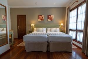 拉拉古纳拉古纳尼瓦利亚Spa大酒店的一间大型卧室,配有两张床和两个窗户