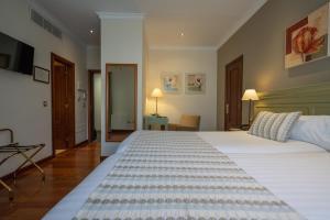 拉拉古纳拉古纳尼瓦利亚Spa大酒店的卧室配有一张白色大床