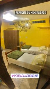 阿雷格里港Pousada Agronomia的黄色墙壁客房的两张床