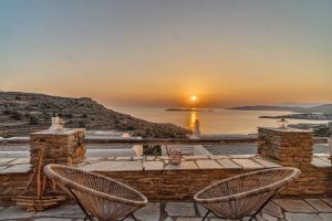 巴特斯欧IRIDA Villa - Sea & Sunset Flats near Batsi的露台享有日落美景,配有两把椅子