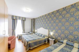 莫利亚诺威尼托LAERTE PALACE HOTEL的酒店客房,设有三张床和一张沙发