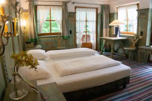 安达赫治Hotel Schrenkhof的一间卧室设有两张床、一张桌子和窗户。
