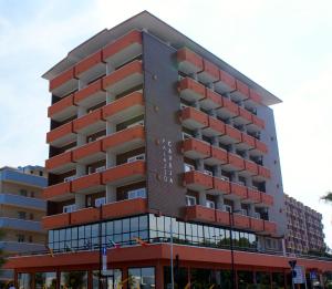 里米尼Hotel Palazzo Caveja的一座高大的红色建筑,有很多窗户