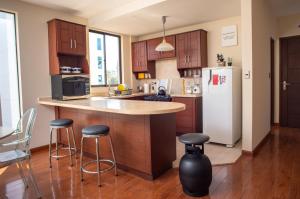 科恰班巴Apartamento Mira 1的厨房配有柜台、冰箱和凳子