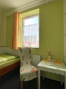 巴特弗兰肯豪森豪斯托斯卡纳旅馆的小房间设有床、椅子和窗户