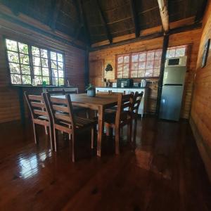 比勒陀利亚Cozy Wood Cabin的一间带桌椅和冰箱的用餐室