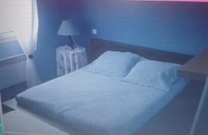 卡纳克villa les pieds dans l eau的卧室配有白色床和蓝色墙壁
