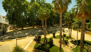 普里埃格·德·科尔多巴Alojamiento Turístico Fuente del Rey的棕榈树公园和喷泉