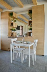 萨卢佐B&B La Luce Verde的白色的用餐室配有白色的桌椅