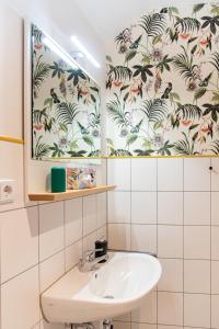 开姆尼茨Apartment mit Industriecharme/ Netflix + WIFI & zentrumsnah的一间带水槽和花卉壁纸的浴室