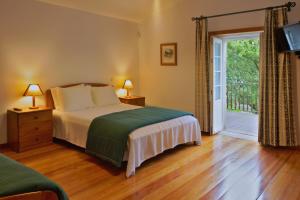 沃加河畔塞维尔Casa da Aldeia的一间卧室设有一张床和一个滑动玻璃门