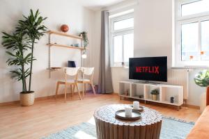 开姆尼茨Stilvolles Apartment mit Balkon / Netflix + WIFI & zentrumsnah的客厅配有电视和桌子
