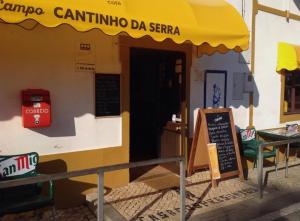 CortelhaCasa De Campo Cantinho Da Serra的一间设有黄色遮阳伞和标志的餐厅