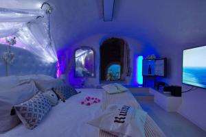 普罗旺斯艾克斯Les Secrets d'Alcôve, nuits Romantiques avec SPA的紫色卧室配有一张床和一台平面电视