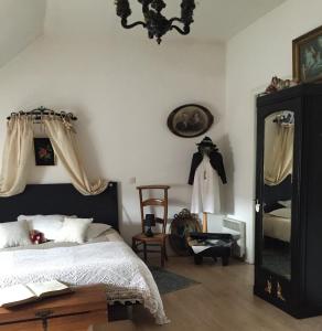 Sallaumines罗玛内公寓的一间卧室配有一张床、镜子和椅子