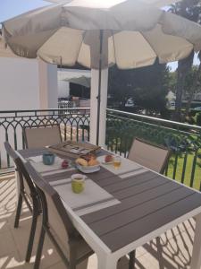 奥霍斯德古阿Algarve Albufeira, quiet apart with pool at 10 mn walk from Praia da Falesia的一张桌子,上面有盘子和一把雨伞