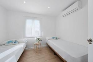 蓬塔格罗萨Apartamento tranquilo a 500m de la playa的白色的客房设有两张床和窗户。
