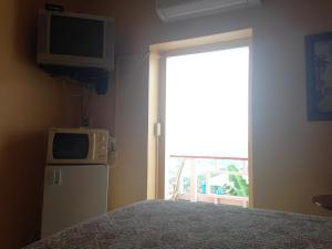 马弗利马弗利酒店的一间卧室配有一张床、电视和冰箱