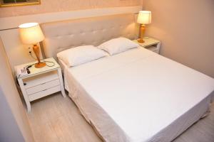 Rolim de MouraEcos Hotel Tourist的卧室配有白色的床和两张台灯。