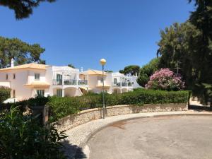 奥霍斯德古阿Algarve Albufeira, quiet apart with pool at 10 mn walk from Praia da Falesia的一座白色的大房子,带有石墙和鲜花