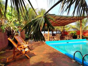 拉斯彭尼塔斯El Belga Loco的游泳池旁的吊床和椅子
