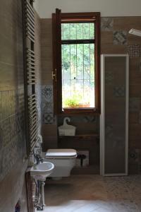 斯特雷萨Nel giardino di Dafne的一间带卫生间、水槽和窗户的浴室