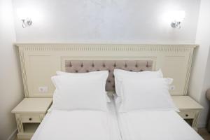 百乐·奥拉内斯蒂Imperial Hotel&Spa - Baile Olanesti的卧室内的两张床和白色枕头