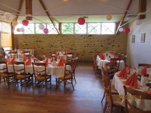 Port-Brillet乐毕雷 - 彭庭酒店的用餐室配有桌椅和红色餐巾