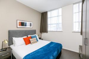 奎斯特新普利茅斯服务式公寓客房内的一张或多张床位