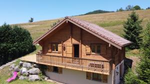 莱瓦尔坦Chalet Les Vosgiennes的小木屋位于山上,设有阳台